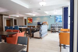 a dining room with tables and chairs in a restaurant at Holiday Inn Express Hotel & Suites Vancouver Mall-Portland Area, an IHG Hotel in Vancouver