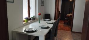 a white table with plates and a vase of flowers on it at Hisa Lescer in Kobarid