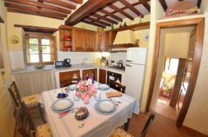 een keuken met een tafel met een witte tafeldoek bij Ferienhaus mit Privatpool für 6 Personen ca 100 qm in Torcigliano di Pescaglia, Toskana Provinz Lucca in Pescaglia