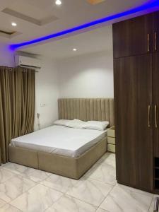 a bedroom with a large bed and a blue light at Loft and Luxe Apartment in Lagos