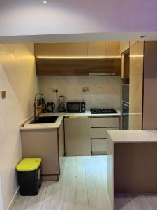 a kitchen with a yellow trash can in a room at Loft and Luxe Apartment in Lagos