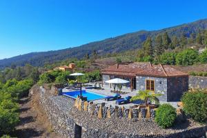 een villa met een zwembad en een huis bij Ferienhaus mit Privatpool für 4 Personen ca 85 qm in Tijarafe, La Palma Westküste von La Palma in Tijarafe