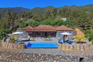 een villa met een zwembad en een huis bij Ferienhaus mit Privatpool für 4 Personen ca 85 qm in Tijarafe, La Palma Westküste von La Palma in Tijarafe