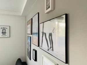 a wall with framed pictures on a wall at STRANDBUTZE by BUTZENFLOTTE Grömitz - Beach Vibes & 100 Meter zum Meer in Grömitz +16 photos