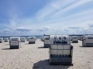 a group of beach chairs sitting on the beach at STRANDBUTZE by BUTZENFLOTTE Grömitz - Beach Vibes & 100 Meter zum Meer in Grömitz