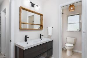 um banheiro com uma pia, um vaso sanitário e um espelho em Nokomis Home Close to Beach em Nokomis mais 42 fotografias