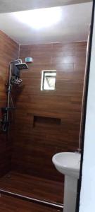 a bathroom with a toilet and a sink and a window at MaNelly Guest House Hotel in Donsol