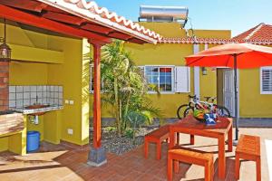 a patio with a table and chairs and an umbrella at Ferienhaus mit Privatpool für 6 Personen ca 108 qm in Las Manchas, La Palma Westküste von La Palma in Puerto Naos