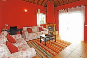 a living room with red walls and a couch and a table at Ferienhaus mit Privatpool für 6 Personen ca 108 qm in Las Manchas, La Palma Westküste von La Palma in Puerto Naos
