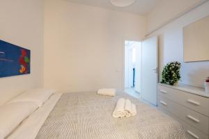 a bedroom with a bed with two slippers on it at Le Mura - Melilli in Trapani