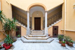 a building with stairs and potted plants in a courtyard at Le Mura - Melilli in Trapani