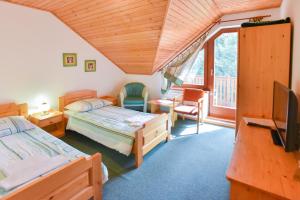een slaapkamer met 2 bedden, een tv en een balkon bij Penzion Kormoran in Námestovo