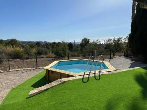 a small swimming pool in a field of green grass at Chalet Cucarres in Calpe