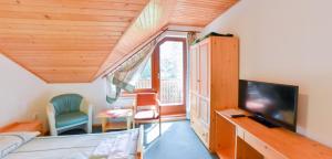 een kamer met een bed, een tv en een raam bij Penzion Kormoran in Námestovo
