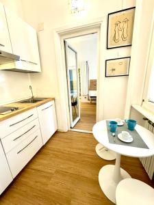 a white kitchen with a white table and a table at viale Angelico in Rome