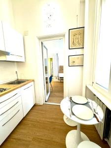 a white kitchen with a table and a sink at viale Angelico in Rome