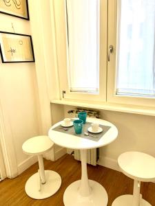 a small white table and two stools in a room at viale Angelico in Rome