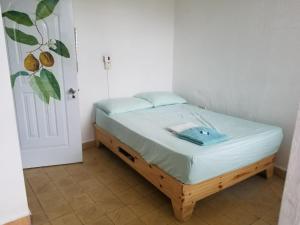 uma pequena cama num quarto com uma porta em Hostel Gato Colonial em Santo Domingo