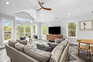 a living room with a couch and a flat screen tv at Sojourn Corolla 6 Bedroom POOL in Corolla