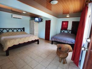 a bedroom with two beds and a television in it at Costa Rica Beach Sanctuary in Bajamar