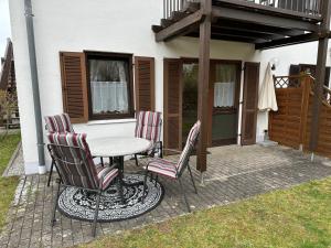 un patio con mesa y 4 sillas en Moderne Ferienwohnung mit kostenlosem Eintritt zum Freibad, en Falkenstein