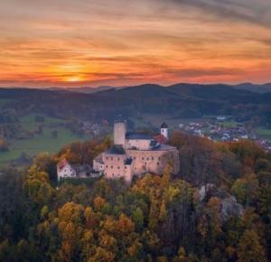 a castle on a hill with a sunset in the background at Günstige Wohnung mit Terrasse im Ferienpark in Falkenstein