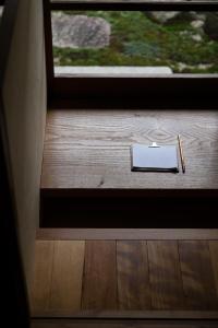 a notebook and pencil on a table next to a window at 奈良町宿 紀寺の家 Naramachiyado Kidera no ie in Nara