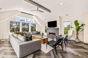 a living room with a couch and a fireplace at Aurora 6 BR Elevator Theater Rec Room Pool & Hot in Corolla