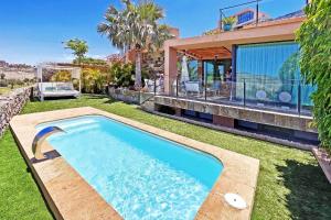 einen Hinterhof mit einem Pool und einem Haus in der Unterkunft Ferienhaus für 4 Personen ca 98 qm in Las Crucitas, Gran Canaria Südküste Gran Canaria in Maspalomas