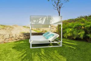 einen Stuhl in einem Glashaus auf einem Rasen in der Unterkunft Ferienhaus für 4 Personen ca 98 qm in Las Crucitas, Gran Canaria Südküste Gran Canaria in Maspalomas