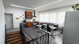 a dining room with tables and chairs and a kitchen at Tölgyfa Vendégház in Balatonszepezd