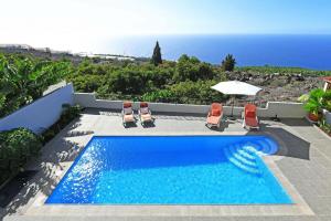 a swimming pool with chairs and a view of the ocean at Ferienhaus für 6 Personen ca 105 qm in La Punta, La Palma Westküste von La Palma in Tijarafe