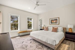 a white bedroom with a large bed and two windows at Aurora 6 BR Elevator Theater Rec Room Pool & Hot in Corolla +70 photos