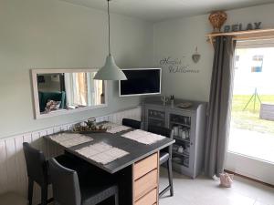 a kitchen with a table with chairs and a television at Ferienhaus mit Sauna b in Zingst