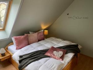 a bedroom with a bed with pink pillows on it at Ferienhaus mit Sauna b in Zingst