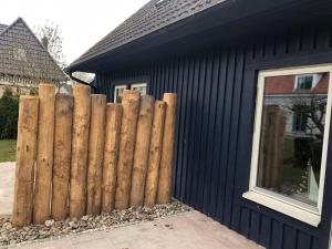 a wooden fence in front of a black house at Ferienhaus mit Sauna b in Zingst +12 photos