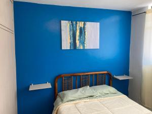 a blue wall with a bed in a room at Casa Skema - Garden in Quito