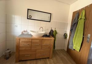 a bathroom with a sink and a mirror on the wall at Ferienwohnung zur Langen Meile in Kalteneggolsfeld +12 photos