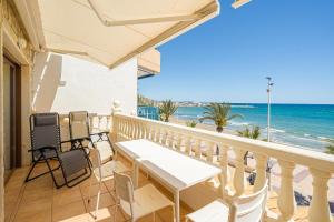 a balcony with a table and chairs and the beach at Front Line Apartment Jakarta 2 in El Campello