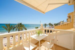 a balcony with a table and chairs and the beach at Front Line Apartment Jakarta 2 in El Campello +29 photos