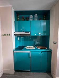 a blue kitchen with a stove and blue cabinets at ComeCasa La Magdeleine 2 Bedrooms Chalet in La Magdeleine