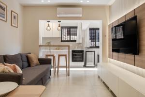 a living room and kitchen with a couch and a television at family apartment in Jerusalem