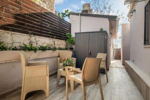 耶路撒冷的住宿－family apartment，庭院配有椅子和桌子,种植了植物