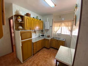 a kitchen with yellow cabinets and a white refrigerator at Casa Virgen de Gracia in Archidona +9 photos
