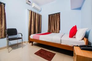 a bedroom with a bed and a chair in it at OYO Flagship Adam's Bridge International Hotel in Patna