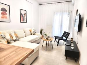 a white living room with a couch and a table at Oditee Thessaloniki Spartis str in Thessaloniki