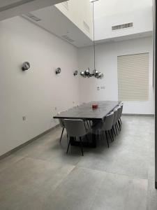 a dining room table and chairs in a white room at 1718 in An Nāmī