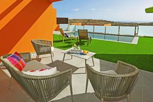 um pátio com cadeiras e uma mesa no telhado em Ferienhaus mit Privatpool für 6 Personen ca 122 qm in Las Crucitas, Gran Canaria Südküste Gran Canaria em Maspalomas