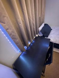 a bed in a room next to a window at London gateway get-away in Hounslow