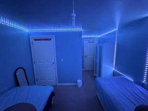 a room with two beds and blue lights at London gateway get-away in Hounslow